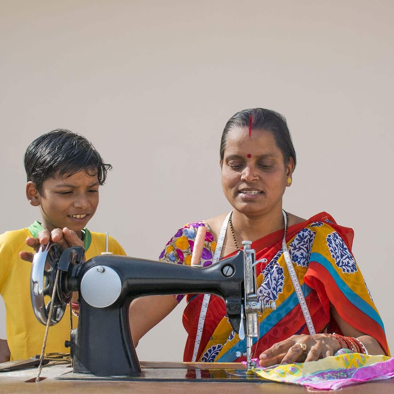 indian woman and boy sewing